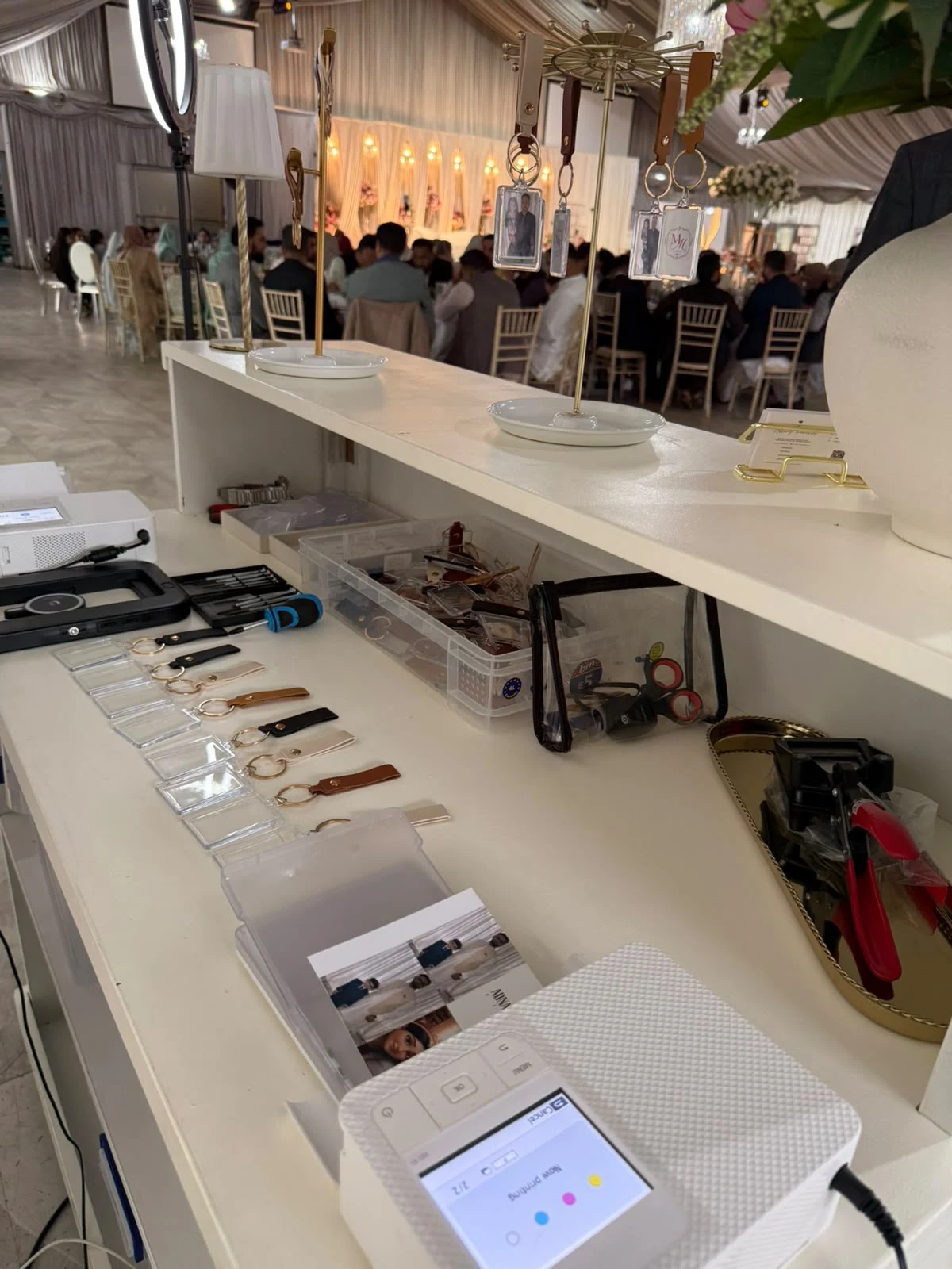 Photographs being printed, trimmed and assembled into keyrings at the Keepsake Bar